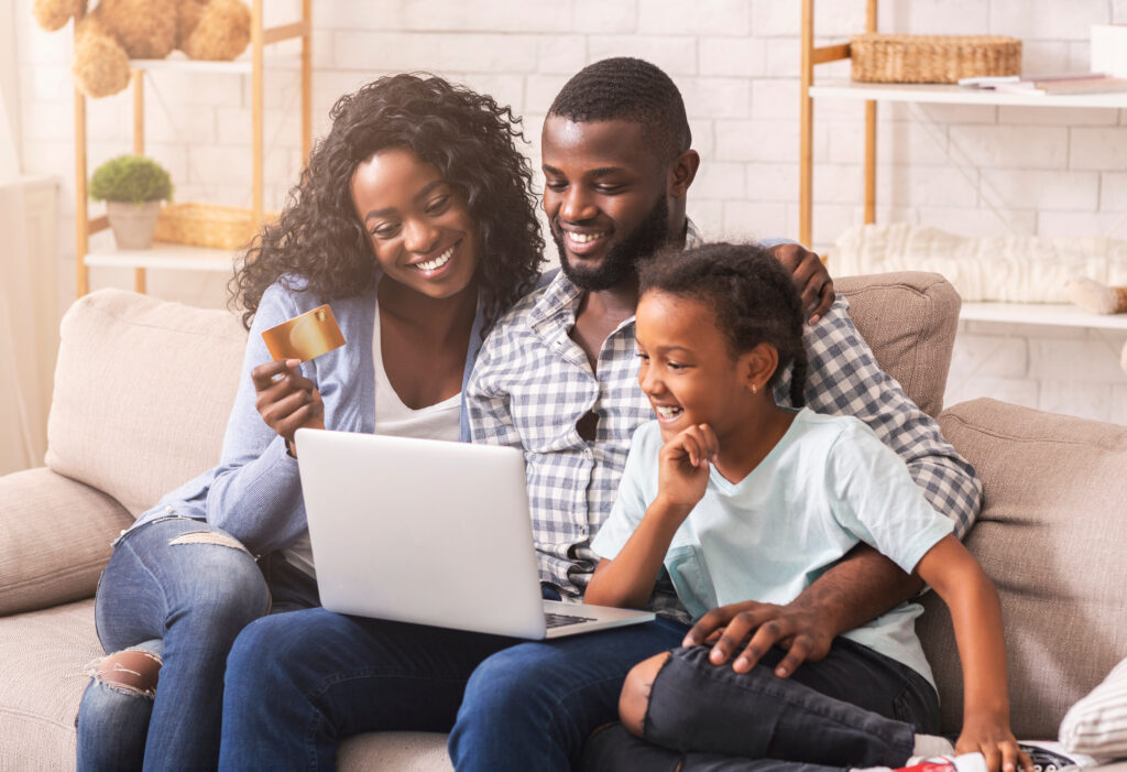 African American family shopping online with laptop and credit card