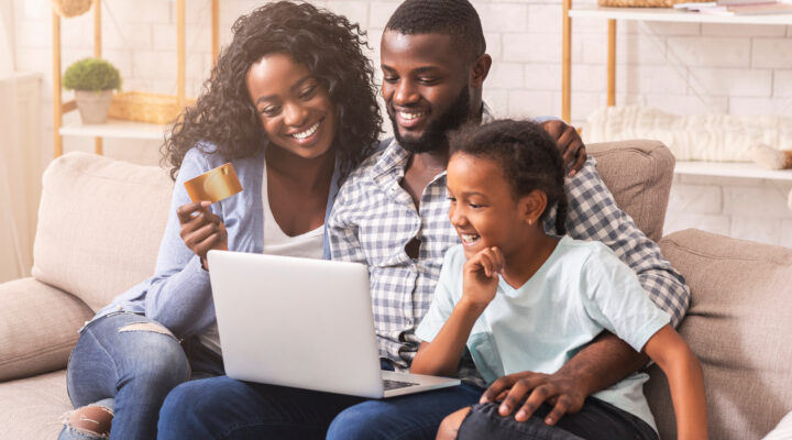 African American family shopping online with laptop and credit card