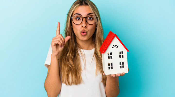 young woman with model home in her hands