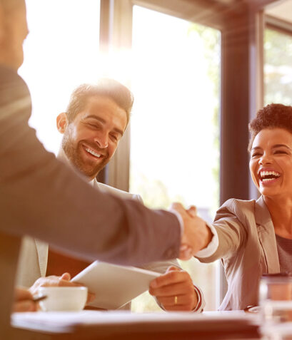 Couple shaking hands with man in suit