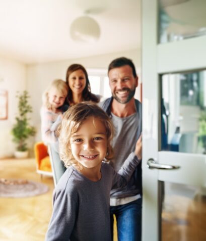 Family holding door open, looking out from inside