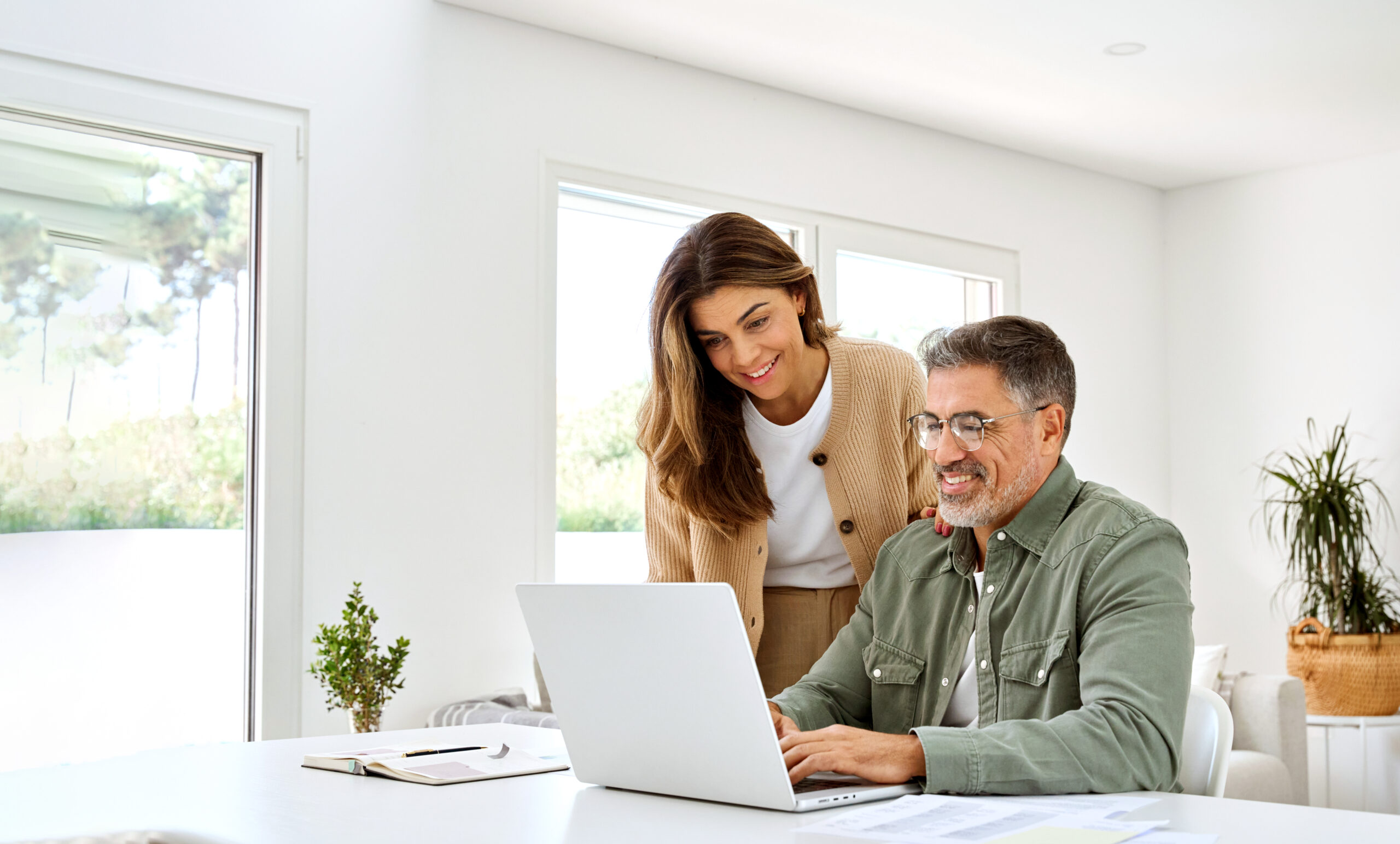 Happy mature older couple using laptop